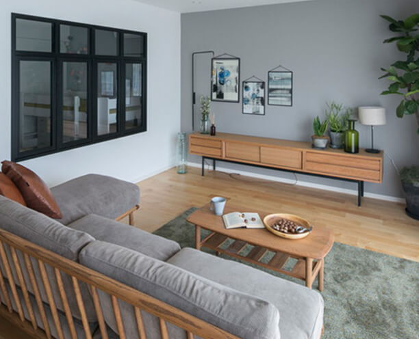 グレーの壁面をアクセントにコーディネートしたリビング。ナチュラルな色調と質感で、昼の自然光も、夜の照明も、やわらかに取り込みます。